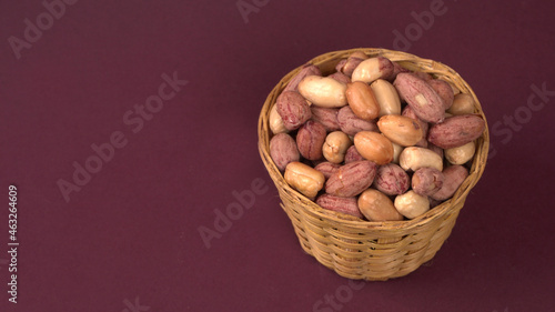 Photography Groundnuts in wooden bowl isolated on plane background, salted roasted peeled nu