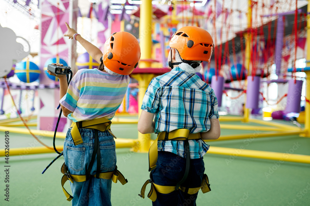 Two children in helmets, young climbers, back view
