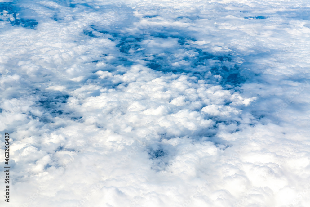 Blue and white cloudscape seen from an aircraft in mid-air Blue and white cloudscape seen from an aircraft in mid-air