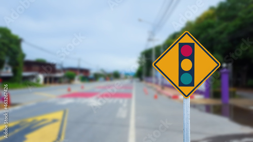 Traffic light sign beside road on blur background