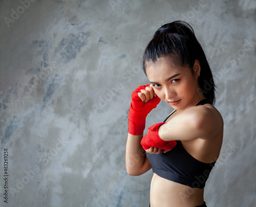 The female boxer sets a defensive stance and fights.