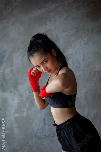 The female boxer sets a defensive stance and fights.
