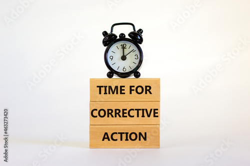 Time for corrective action symbol. Wooden blocks with words 'Time for corrective action' on a beautiful white background. Black alarm clock. Business, time for corrective action concept. Copy space.