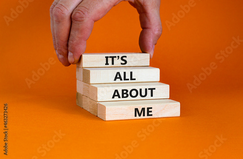 It is all about me symbol. Wooden blocks with words 'It is all about me'. Beautiful orange background. Businessman hand. Copy space. Business and it is all about me concept. photo