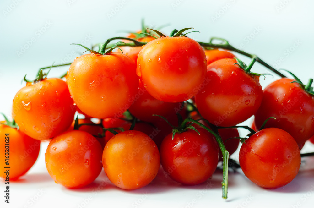 Covered with drops of water, fresh tomatoes with sprigs on white background Covered with drops of water, fresh tomatoes with sprigs on white background