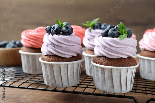 Sweet cupcakes with fresh blueberries on wooden table, closeup