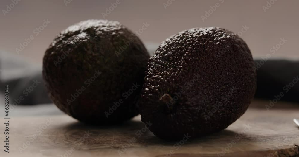 Slow motion cut dark ripe avocado with knife closeup Slow motion cut dark ripe avocado with knife closeup