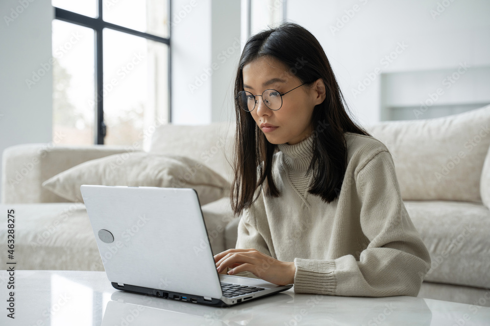 Asian businesswoman-entrepreneur using a computer, looking at a screen, working at an office desk, a smiling Asian professional woman typing e-mail on a laptop in the workplace Asian businesswoman-entrepreneur using a computer, looking at a screen, working at an office desk, a smiling Asian professional woman typing e-mail on a laptop in the workplace