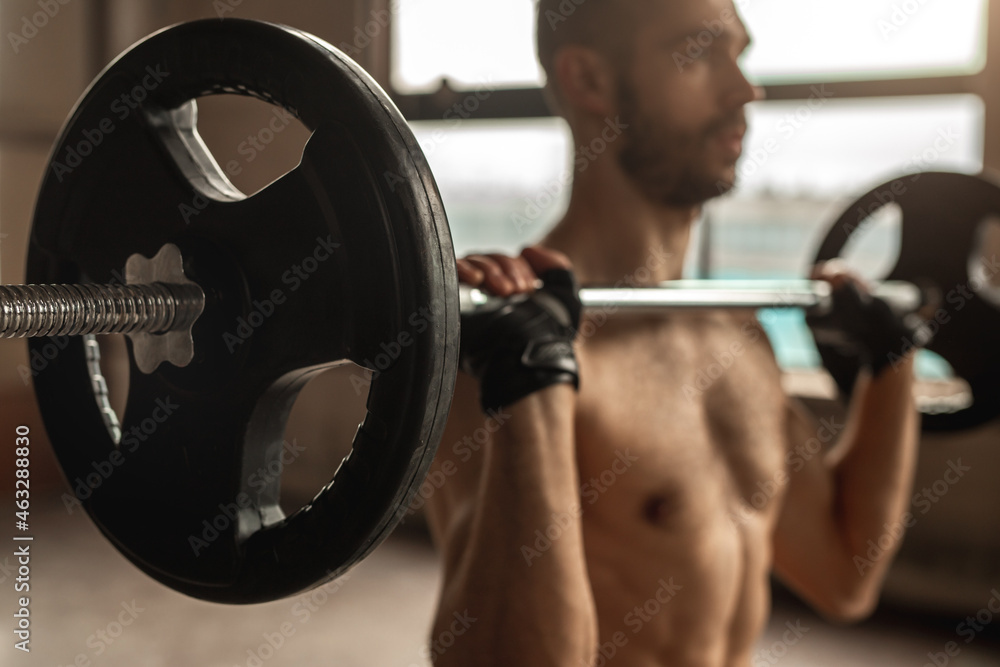 Crop strong bodybuilder raising barbell in gym Crop strong bodybuilder raising barbell in gym