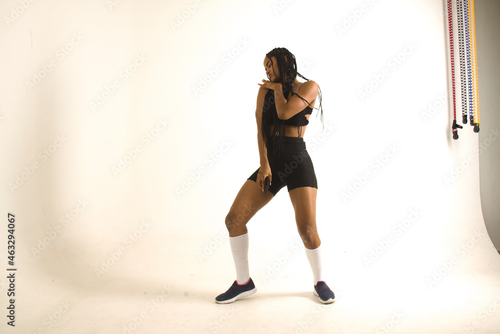 woman with full-length loose braids and cell phone in hands, in sportswear