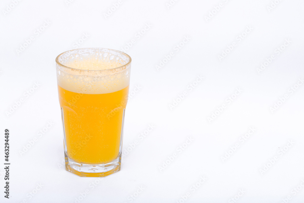 A glass of vitamin orange juice cool on a white background A glass of vitamin orange juice cool on a white background