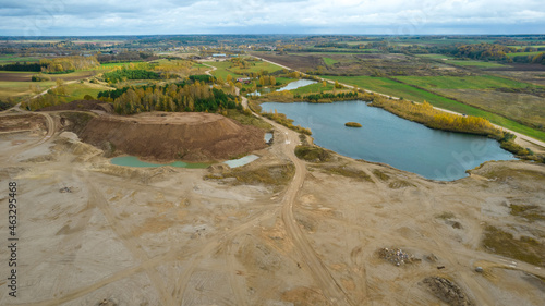Open pit gravel mining. Little lake or pond of unusual shape with a beautiful autumn nature and gravel piles photographed from above with a drone. Real is beautiful  photo