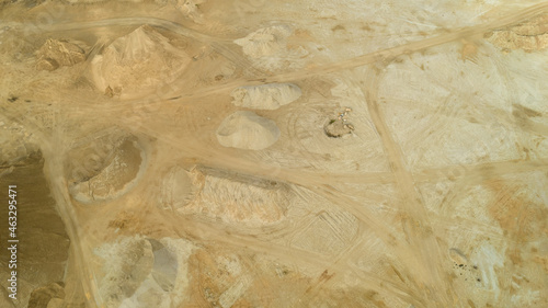 Open pit gravel mining. Large piles of construction sand and gravel used for asphalt production and building. Limestone quarry, mining rocks and stones photographed from above with a drone. 
