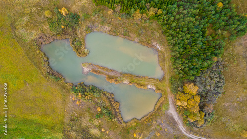 Little lake or pond of unusual shape with a beautiful autumn nature photographed from above with a drone. Real is beautiful  photo