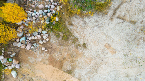 Open pit gravel mining sight with gravel field, big stones and beautiful autumn nature photographed from above with a drone. Mining industry  photo