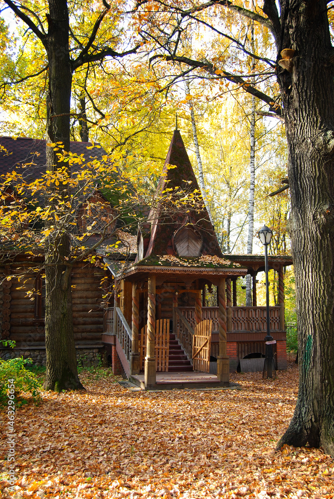 Autumn landscape. An old wooden hut among fallen leaves and autumn trees. Wooden building. Architecture. Yellow trees near the hut. Autumn landscape. An old wooden hut among fallen leaves and autumn trees. Wooden building. Architecture. Yellow trees near the hut.