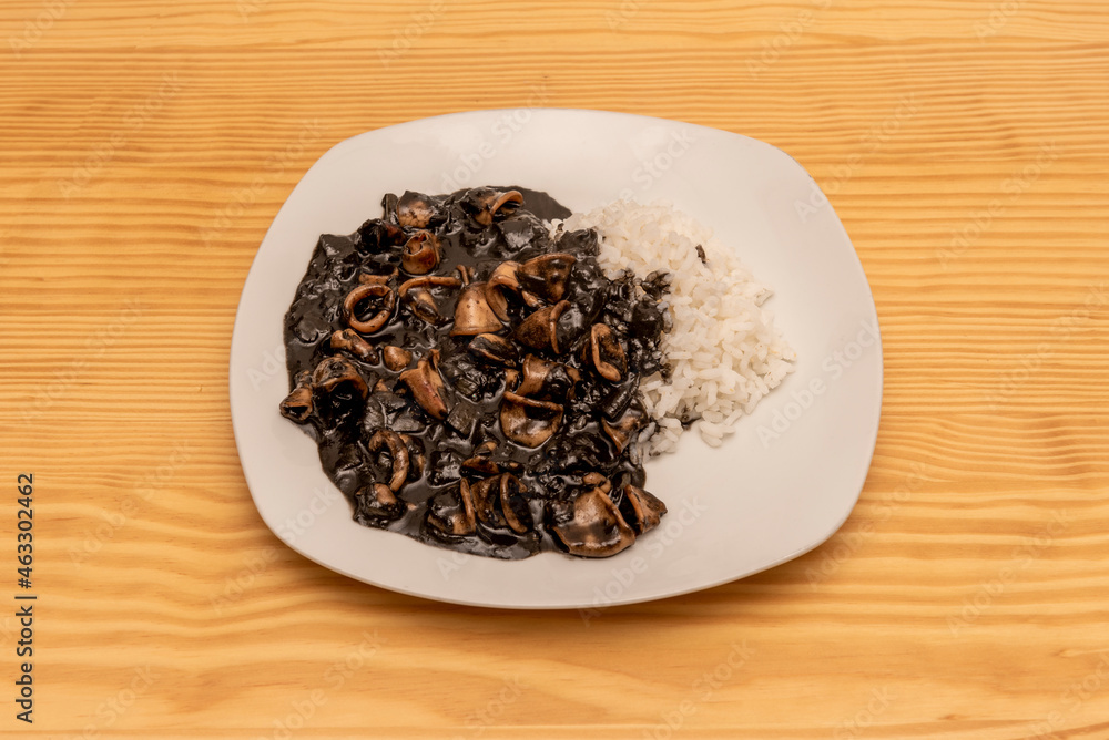 Typical recipe from the north of Spain with squid with ink sauce and white rice garnish Typical recipe from the north of Spain with squid with ink sauce and white rice garnish