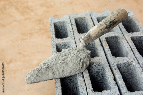 Cement powder or mortar with  trowel put on the Concrete brick for construction work..