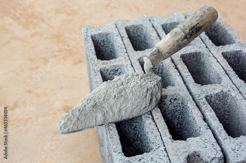 Cement powder or mortar with  trowel put on the Concrete brick for construction work..