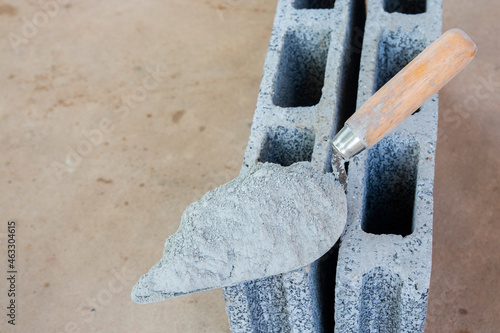 Cement powder or mortar with  trowel put on the Concrete brick for construction work..
