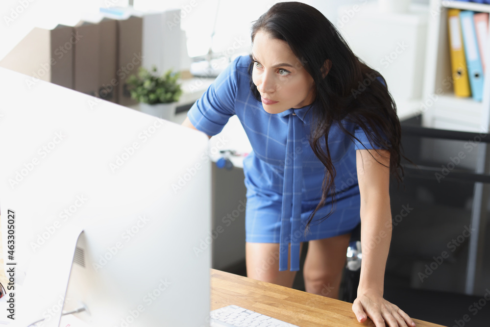 Surprised disgruntled woman looking at computer monitor at workplace Surprised disgruntled woman looking at computer monitor at workplace