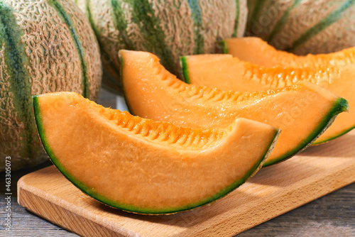 ripe sweet melon on wood plate and old wooden background.