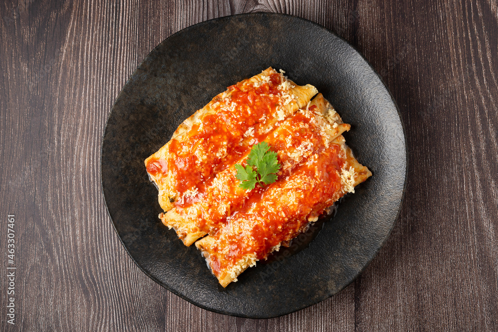 Pancakes stuffed with minced meat and topped with tomato sauce and grated cheese. Pancakes stuffed with minced meat and topped with tomato sauce and grated cheese.