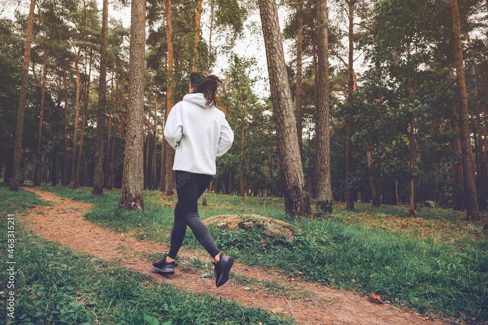 Woman running in autumn forest. Exercising outdoors Woman running in autumn forest. Exercising outdoors