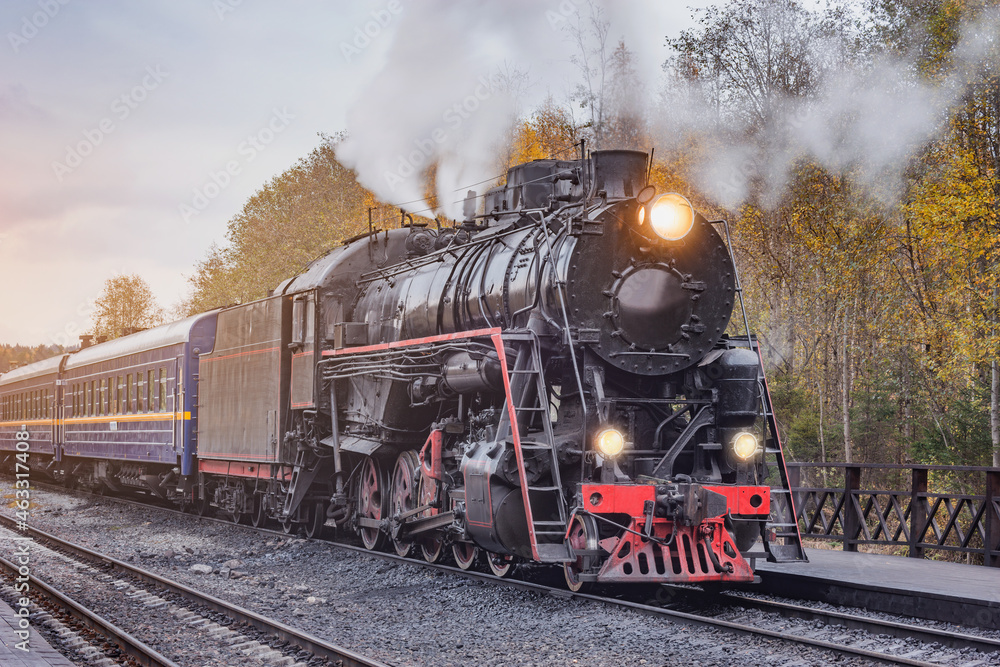 Fototapeta premium Retro steam train departs from the station wooden platform.