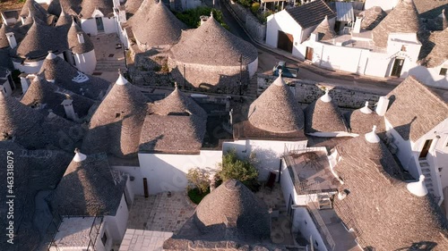 Aerial view of trulli of alberobello town in Italy. drone fly over old town buildings at sunrise
