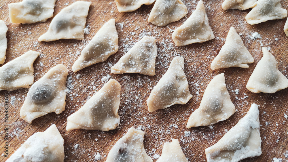 Traditional Turkish manti. Famous Turkish food manti on the wooden table. Close up of handmade manti. Traditional Turkish dumplings. Dumplings with meat onion and spice Turkish dumplings recipe Traditional Turkish manti. Famous Turkish food manti on the wooden table. Close up of handmade manti. Traditional Turkish dumplings. Dumplings with meat onion and spice Turkish dumplings recipe