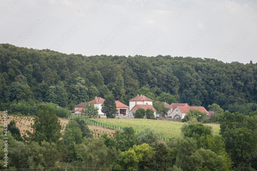Selective blur on a typical seosko domacinstvo, a Serbian farm estate made of various houses, buildings and barns, surrounded by fields. Serbia is an agricultural country...