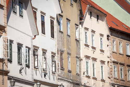 Typical medieval and austro hungarian Facades of non renovated old appartment residential building in a street of old town, with open windows, in the historical center of Ljubljana, Slovenia