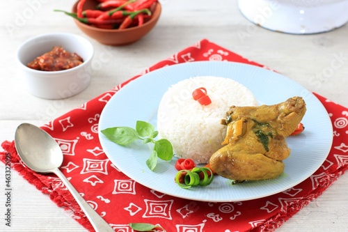 Indonesian traditional Cuisine: Ayam Woku, or Turmeric Spiced Chicken with Asian Sweet Basil, a Manadonese Chicken Dish Served with Rice photo