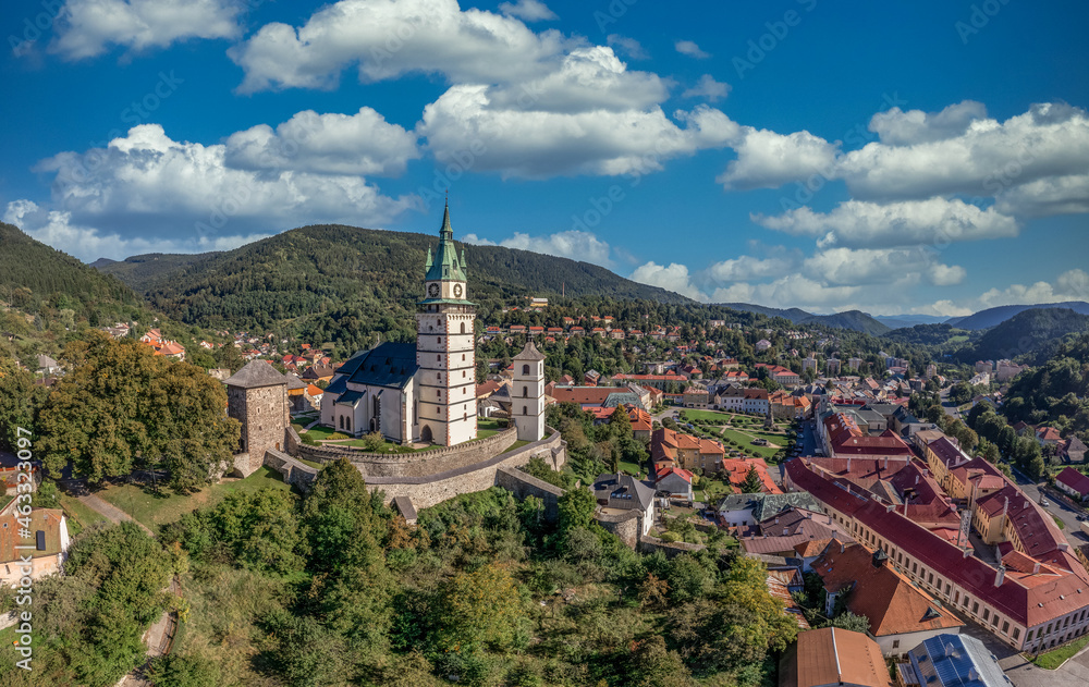 Aerial view of Gothic St. Caterina fortified church in Kremnica, surrounded by double walls, guard towers, gate tower, moat above the medieval walled town center guarding the gold mines in Slovakia