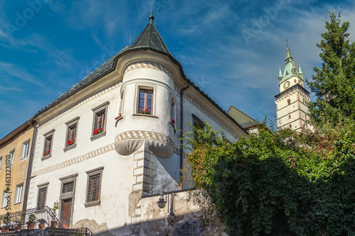 Renaissance mansion in Kremnica with turret like tower in the city of gold in Slovakia with imposing castle church bell tower in the background photo