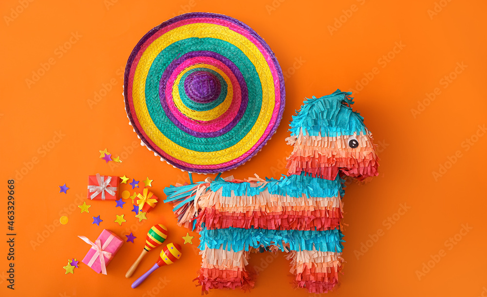 Obraz premium Mexican pinata with sombrero hat, maracas and gifts on color background
