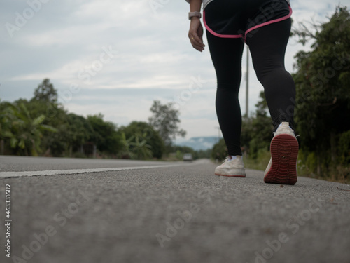 Female runners running on the road trail in morning training for marathon and fitness. Healthy lifestyle concept. Athlete running exercising outdoors. Close-up legs.