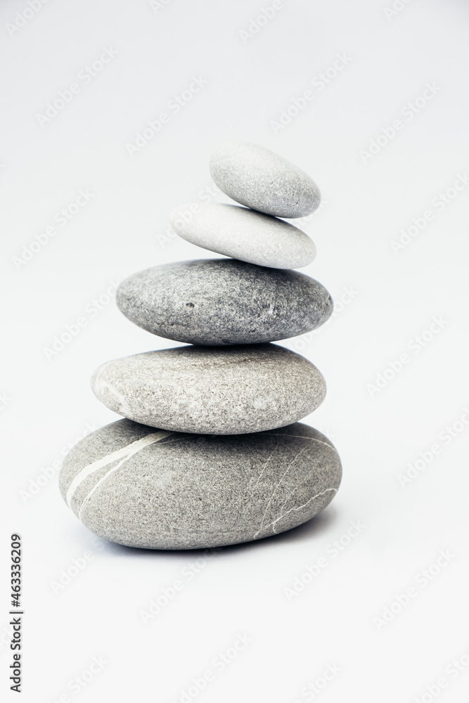 Stone cairn on light background, stones tower, simple poise stones. Purity harmony and Balance Concept. Vertical photo. Stone cairn on light background, stones tower, simple poise stones. Purity harmony and Balance Concept. Vertical photo.