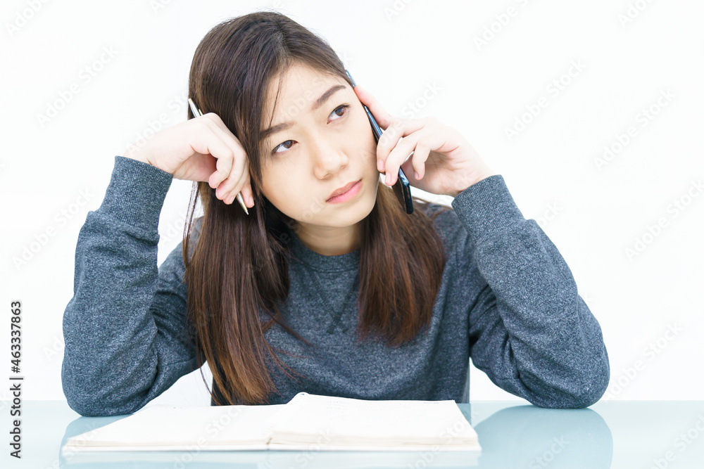 Woman using mobile phone and writing notebook Woman using mobile phone and writing notebook