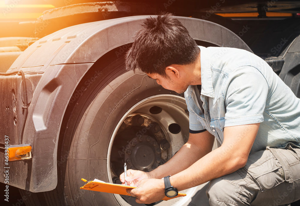 Asian Auto Mechanic is Inspecting Truck Wheels Tires. Inspection Maintenance and Safety Driving.