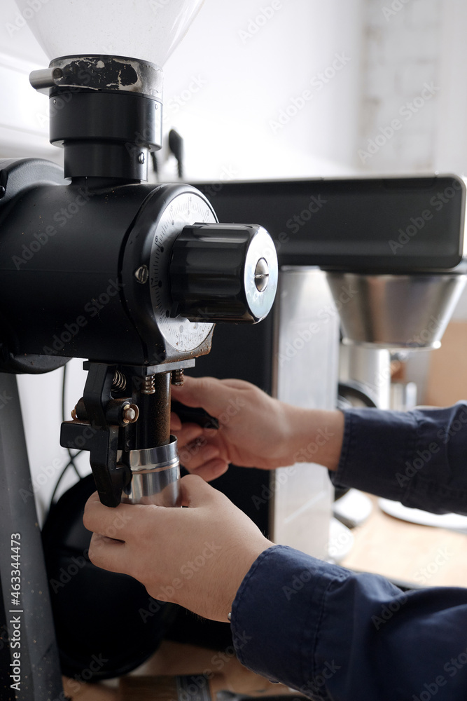 Grinding coffee beans into a cup Grinding coffee beans into a cup