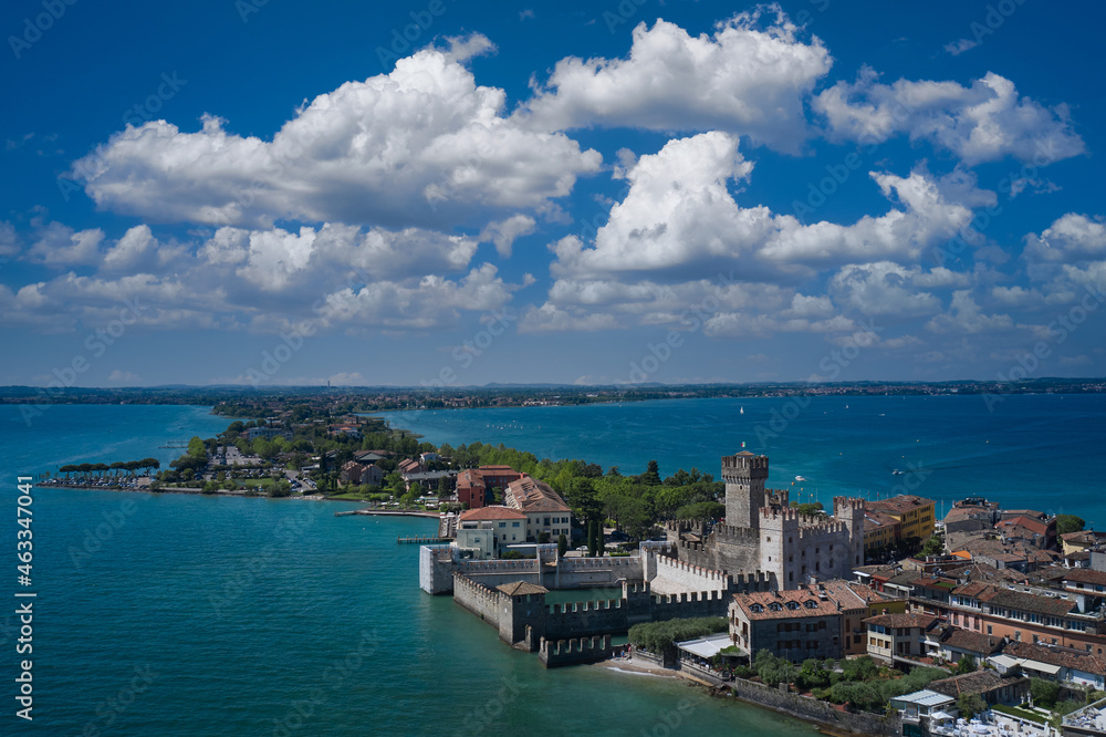 Top view of the 13th century castle. Aerial panorama of Sirmione castle, Lake Garda, Italy. Italian castles Scaligero on the water. Flag of Italy on the towers of the castle on Lake Garda.