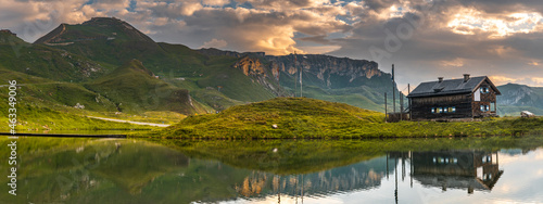 Panoramic View over Wooden Hut Reflection in Alpine Lake . Mountains Landscape at Sunrise