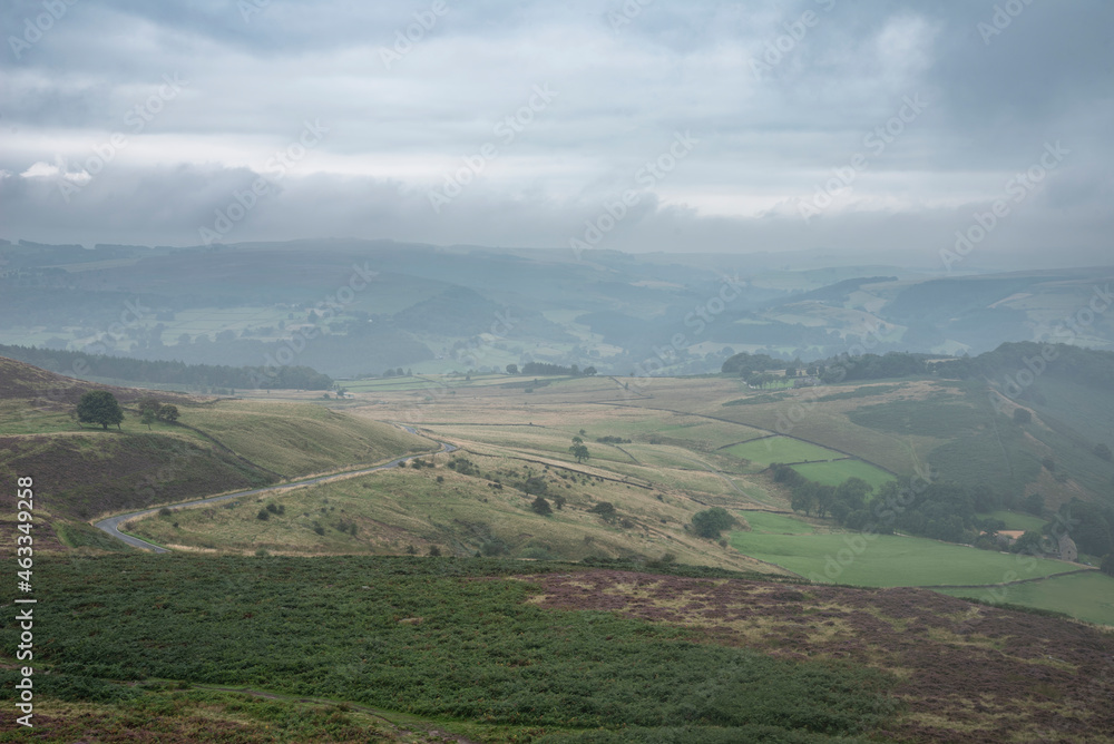 Stunning landscape image of the view from Higger Tor in the Peak District National Park in Egnland with light fog across the rolling fields