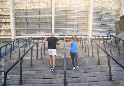 Back view of sporty couple in sportswear jogging while training together outdoors on the city stairs © Kostiantyn