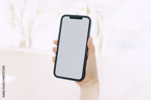 The hand holding the iPhone vertically.