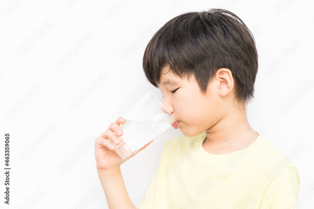 little boy drinking water with a glass cup. little boy drinking water with a glass cup.