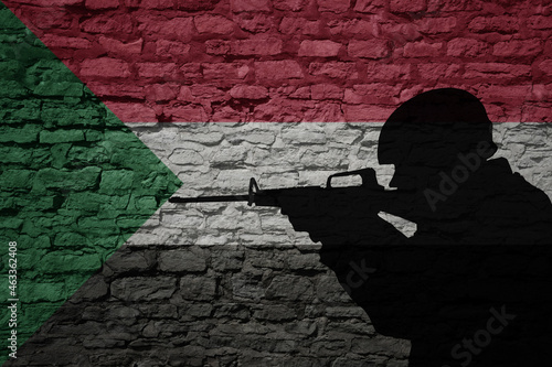Εκτύπωση καμβά Soldier silhouette on the old brick wall with flag of sudan country