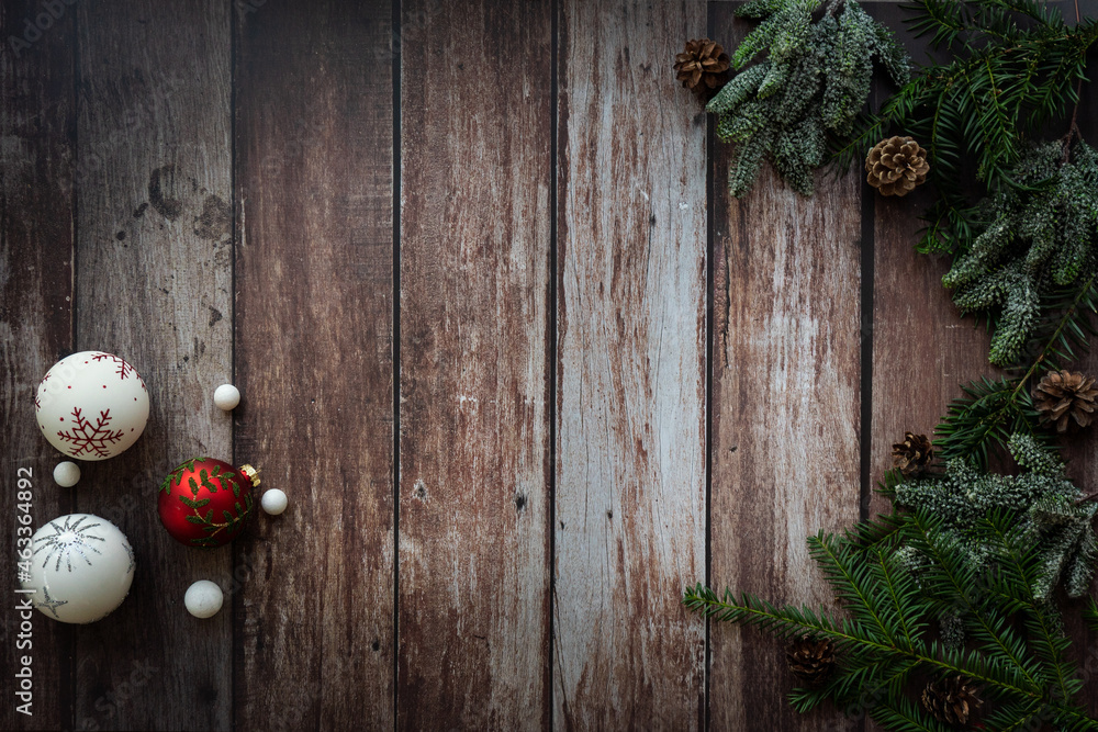 christmas decoration with christmas balls, green branches and pine cones on a rustic, old, wooden background, vintage style